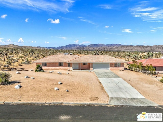 ranch-style home with a garage and a mountain view