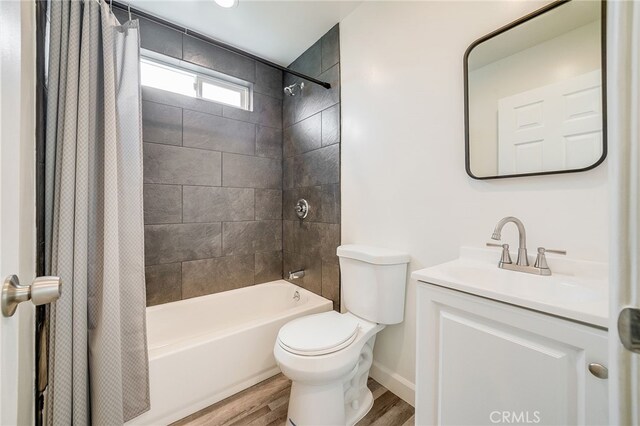 full bathroom featuring hardwood / wood-style floors, vanity, toilet, and shower / bath combo