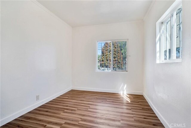 unfurnished room with hardwood / wood-style floors and ornamental molding