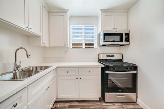 kitchen featuring light wood-type flooring, white cabinetry, sink, and appliances with stainless steel finishes