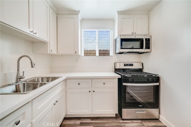 916 W 88th St, Los Angeles, CA 90044 - kitchen with a sink, appliances with stainless steel finishes, wood finished floors, and white cabinets