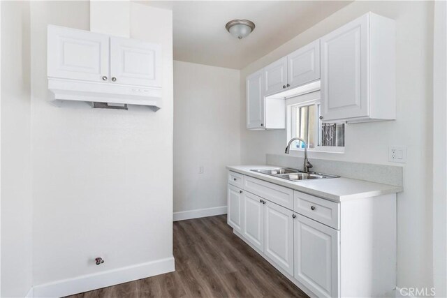 kitchen featuring dark hardwood / wood-style flooring, sink, and white cabinets