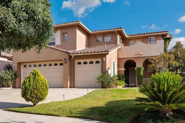 mediterranean / spanish-style home featuring a front lawn and a garage