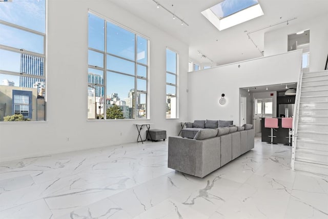 living room featuring a skylight and a high ceiling