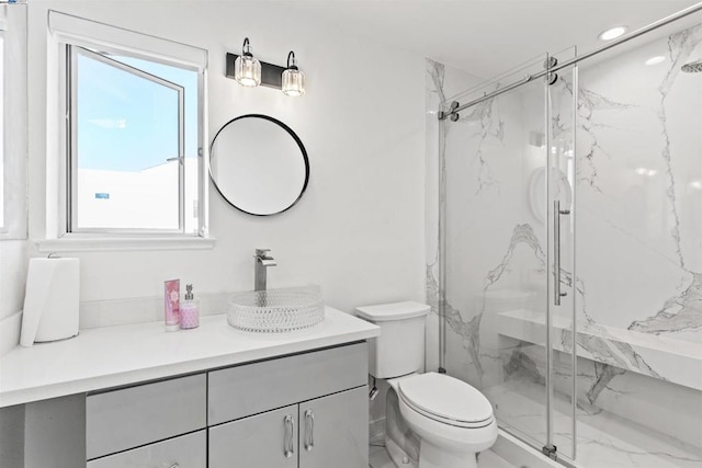 bathroom featuring toilet, a shower with door, and vanity