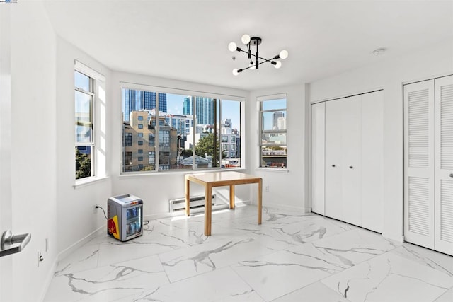 interior space with a baseboard radiator and a chandelier