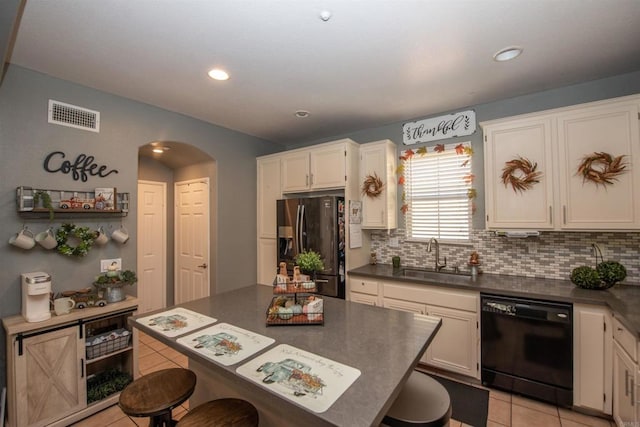 kitchen with tasteful backsplash, dishwasher, sink, light tile patterned floors, and stainless steel refrigerator with ice dispenser