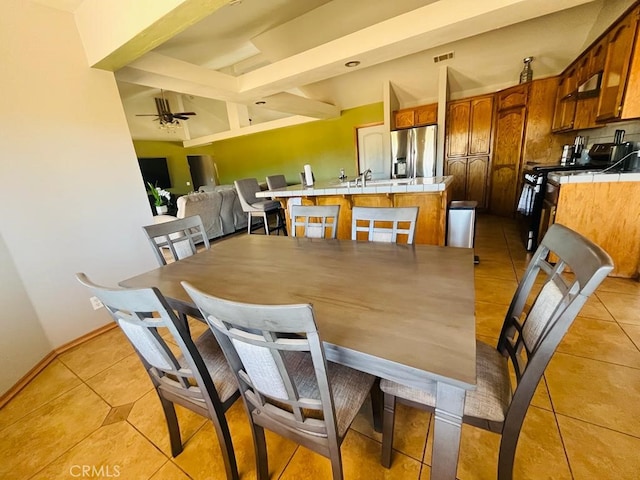 tiled dining area with beam ceiling and ceiling fan