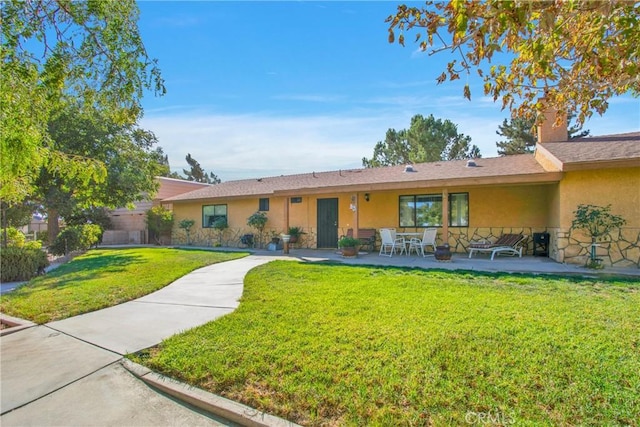 ranch-style house featuring a front lawn and a patio