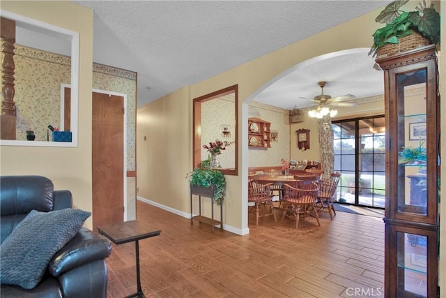 living room featuring ceiling fan, a textured ceiling, and hardwood / wood-style floors