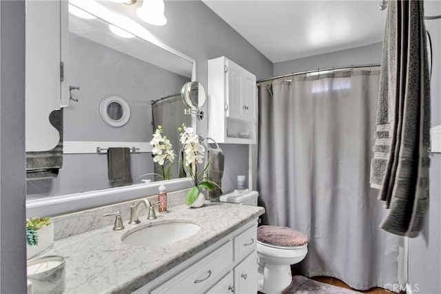 bathroom with toilet, vanity, and walk in shower