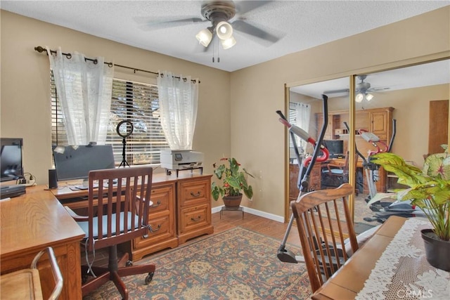 office space with a textured ceiling, ceiling fan, plenty of natural light, and hardwood / wood-style flooring