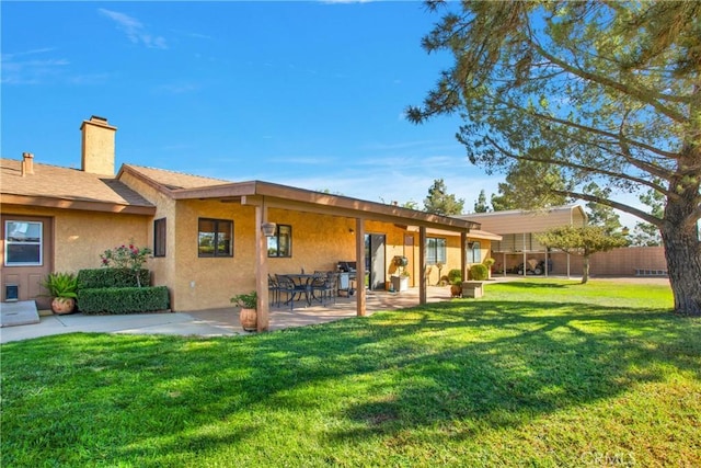 rear view of property with a yard and a patio