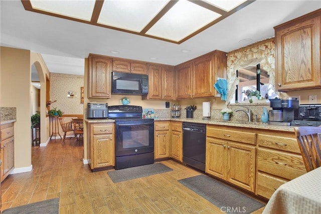 kitchen featuring sink, light hardwood / wood-style flooring, and black appliances