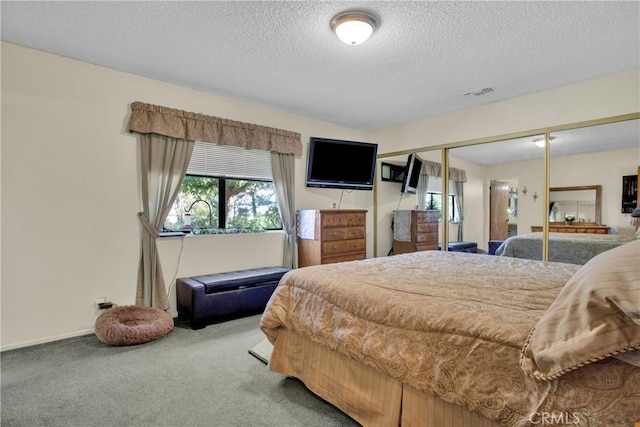 carpeted bedroom with a textured ceiling and a closet