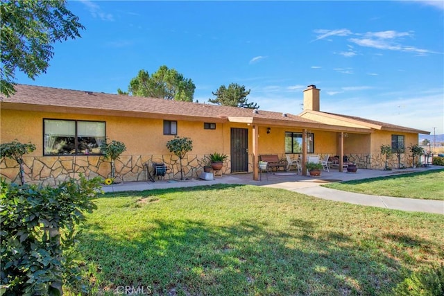 view of front of house with a front lawn and a patio area