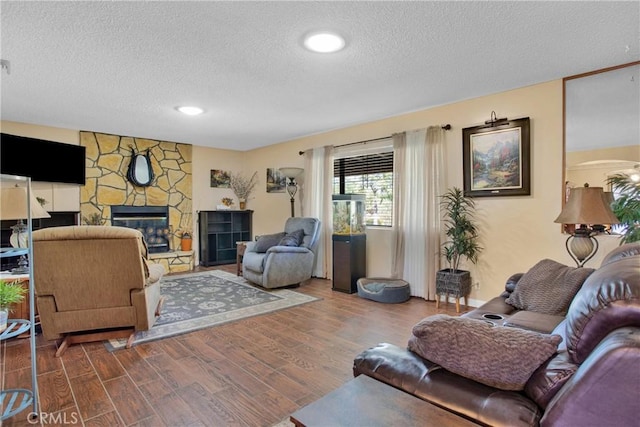 living room with a fireplace, a textured ceiling, and hardwood / wood-style flooring