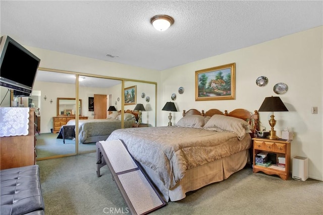 carpeted bedroom with a textured ceiling and a closet