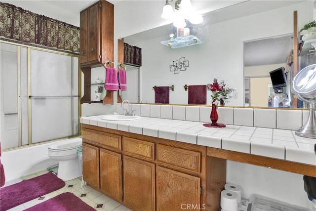 full bathroom featuring toilet, tile patterned flooring, enclosed tub / shower combo, and vanity