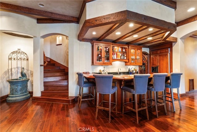 bar with beam ceiling, dark hardwood / wood-style floors, and sink