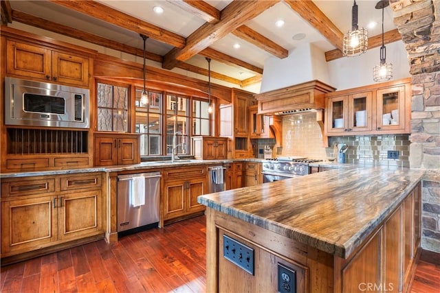 kitchen with tasteful backsplash, kitchen peninsula, sink, hanging light fixtures, and appliances with stainless steel finishes