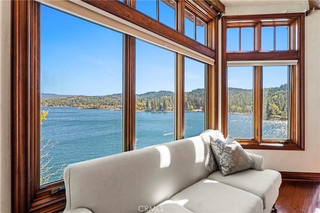 sunroom featuring a water view