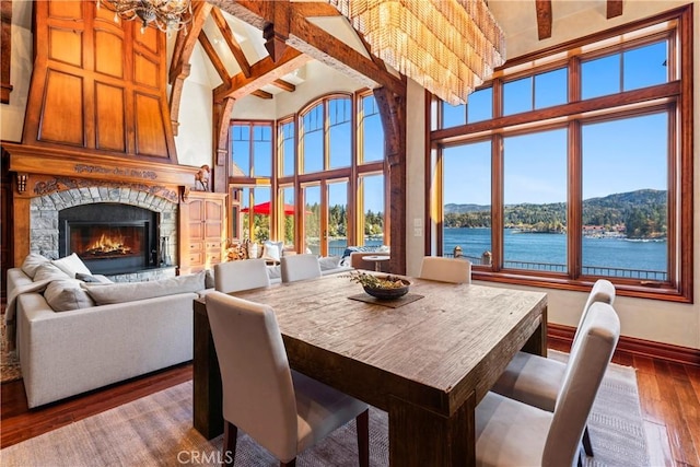 dining area featuring a chandelier, a healthy amount of sunlight, a water view, and wood-type flooring