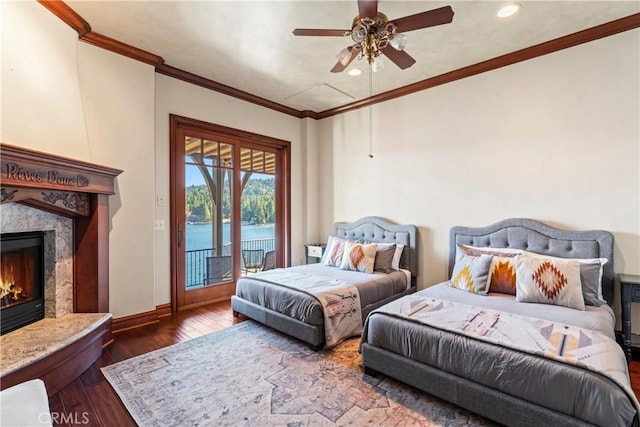 bedroom with ceiling fan, access to exterior, hardwood / wood-style floors, a water view, and a high end fireplace