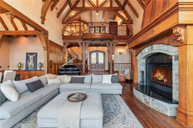 living room featuring high vaulted ceiling, beam ceiling, a tiled fireplace, and dark hardwood / wood-style floors