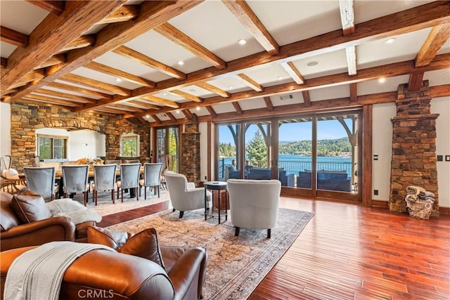 living room featuring beam ceiling, a water view, and hardwood / wood-style flooring