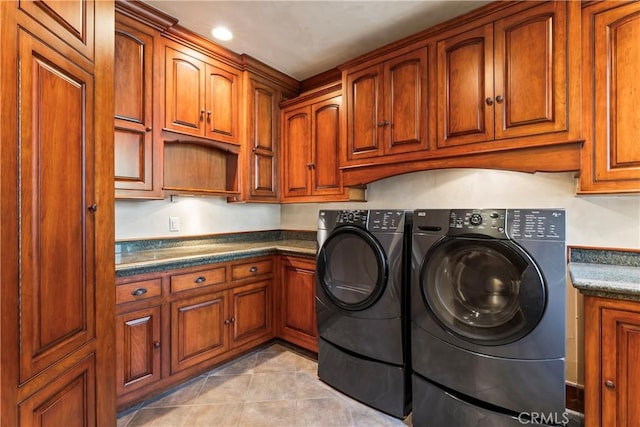 washroom featuring light tile patterned floors, separate washer and dryer, and cabinets