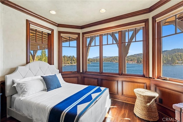 bedroom featuring a water view, dark wood-type flooring, and crown molding