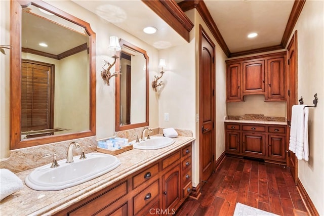 bathroom featuring crown molding, hardwood / wood-style floors, and vanity