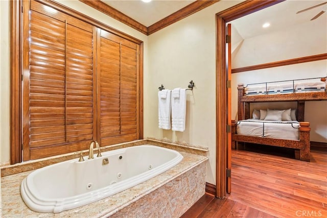 bathroom with a relaxing tiled tub, wood-type flooring, and crown molding