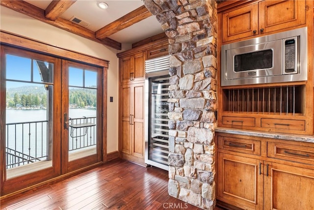 doorway to outside with dark wood-type flooring, beam ceiling, and beverage cooler