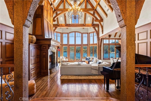 living room featuring a notable chandelier, beam ceiling, hardwood / wood-style flooring, and high vaulted ceiling