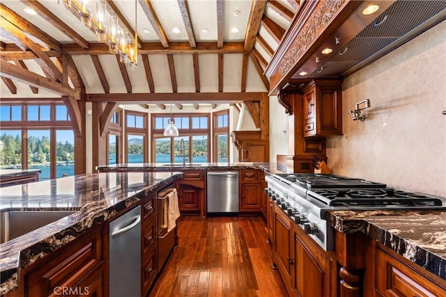 kitchen with stainless steel appliances, dark stone countertops, an inviting chandelier, lofted ceiling with beams, and a water view