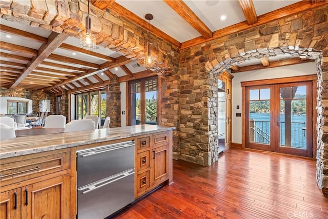 kitchen featuring light stone countertops, dark hardwood / wood-style flooring, french doors, hanging light fixtures, and lofted ceiling with beams