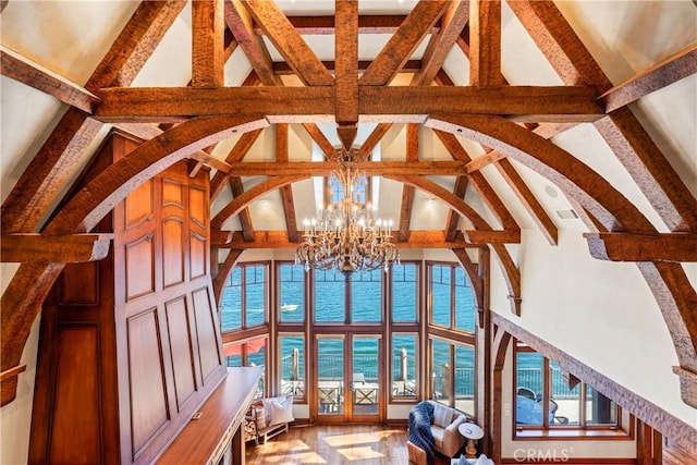 interior space featuring a water view, beam ceiling, an inviting chandelier, and high vaulted ceiling