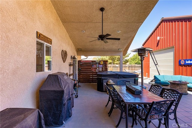 view of patio featuring an outdoor living space, ceiling fan, an outdoor structure, and a hot tub