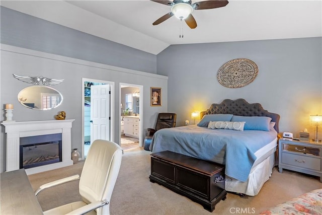 bedroom featuring light carpet, ensuite bathroom, vaulted ceiling, and ceiling fan