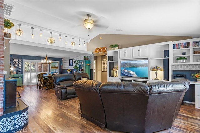 living room featuring ceiling fan with notable chandelier, dark hardwood / wood-style floors, and vaulted ceiling