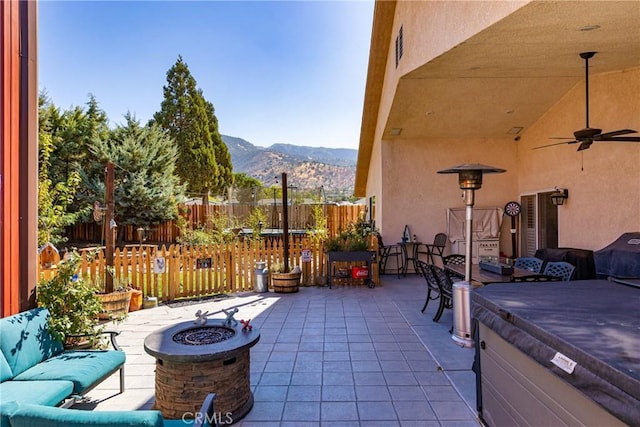 view of patio / terrace with a mountain view, ceiling fan, and an outdoor living space with a fire pit