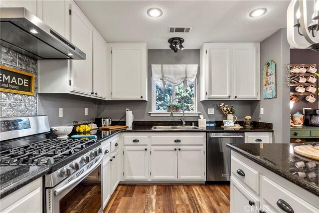 kitchen with sink, stainless steel appliances, white cabinetry, and exhaust hood