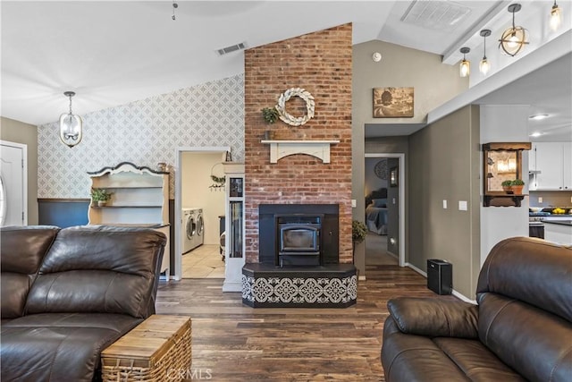 living room featuring hardwood / wood-style floors, washer and dryer, and a wood stove