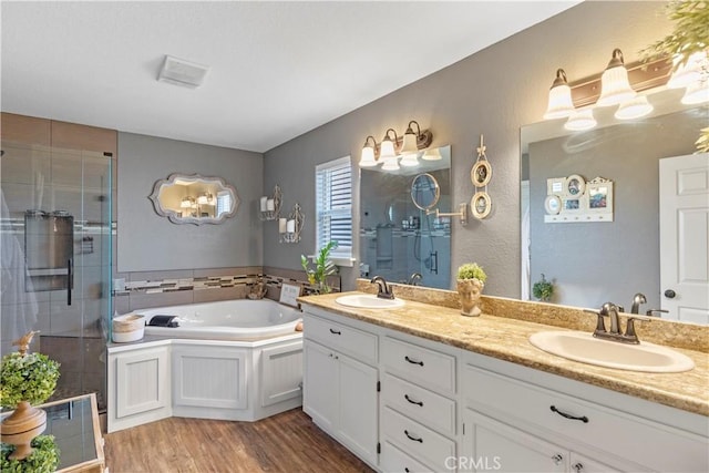 bathroom featuring vanity, wood-type flooring, and shower with separate bathtub