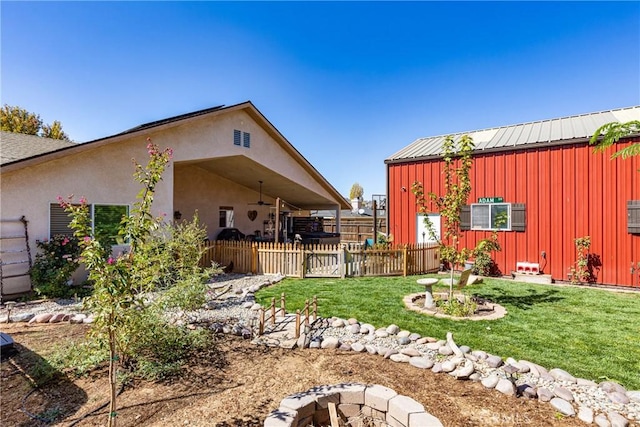 view of yard featuring a fire pit and ceiling fan