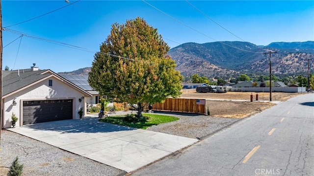 view of front of home featuring a mountain view, a garage, and solar panels