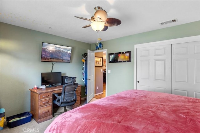 carpeted bedroom featuring ceiling fan and a closet