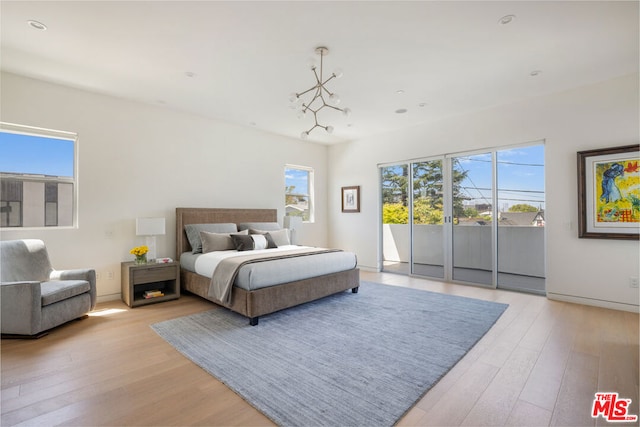 bedroom featuring access to exterior, light hardwood / wood-style flooring, and multiple windows